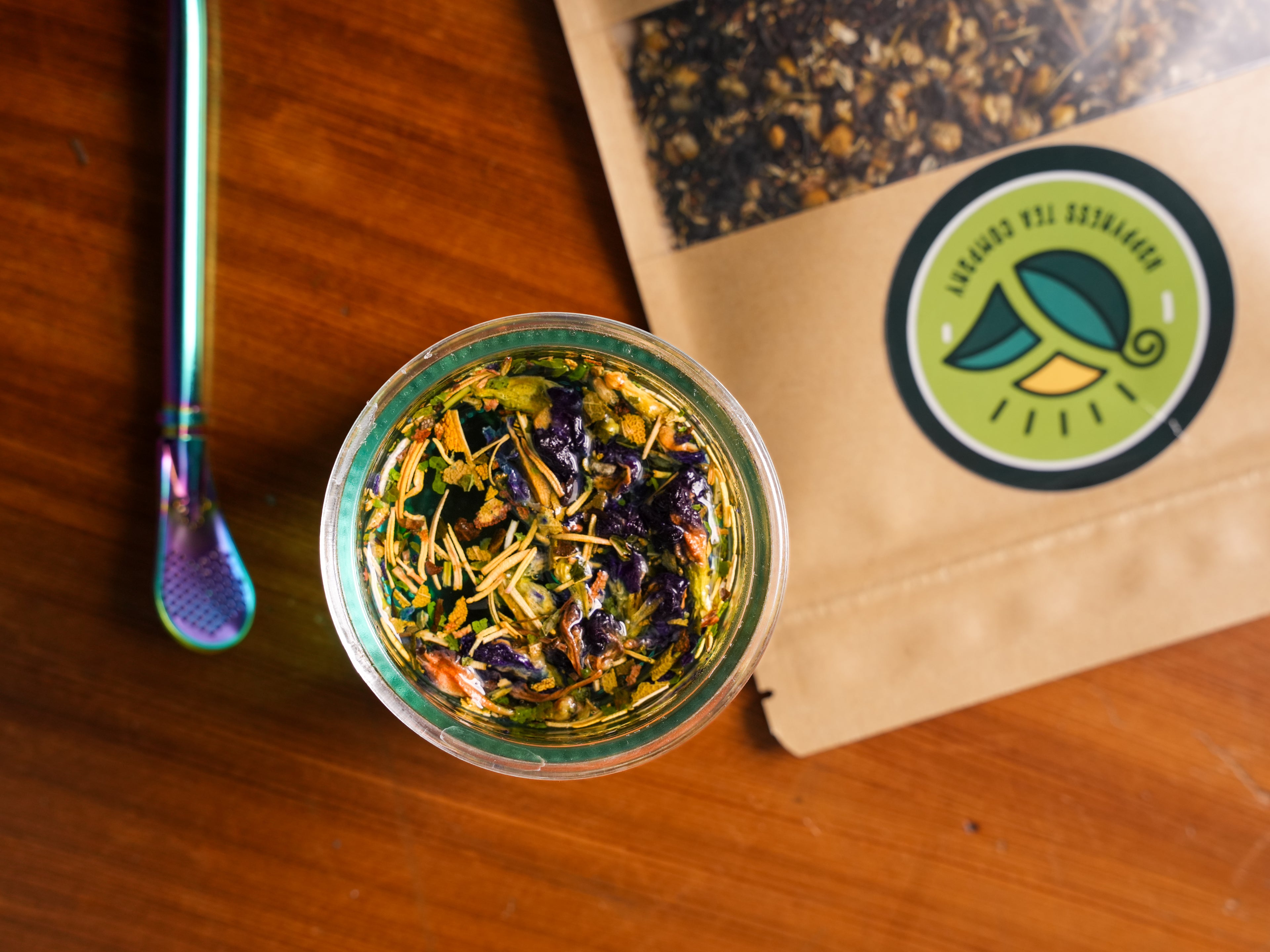 Cup of Blue Morpho Loose Leaf Tea with Bombilla and tea package. Butterfly Pea Flower, Rosemary, Sage, Lemon Balm