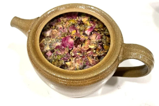 Loose-leaf In Kensington Gardens floral chai blend with hibiscus, rose petals, chamomile flowers, cinnamon, elderflower, and lavender.